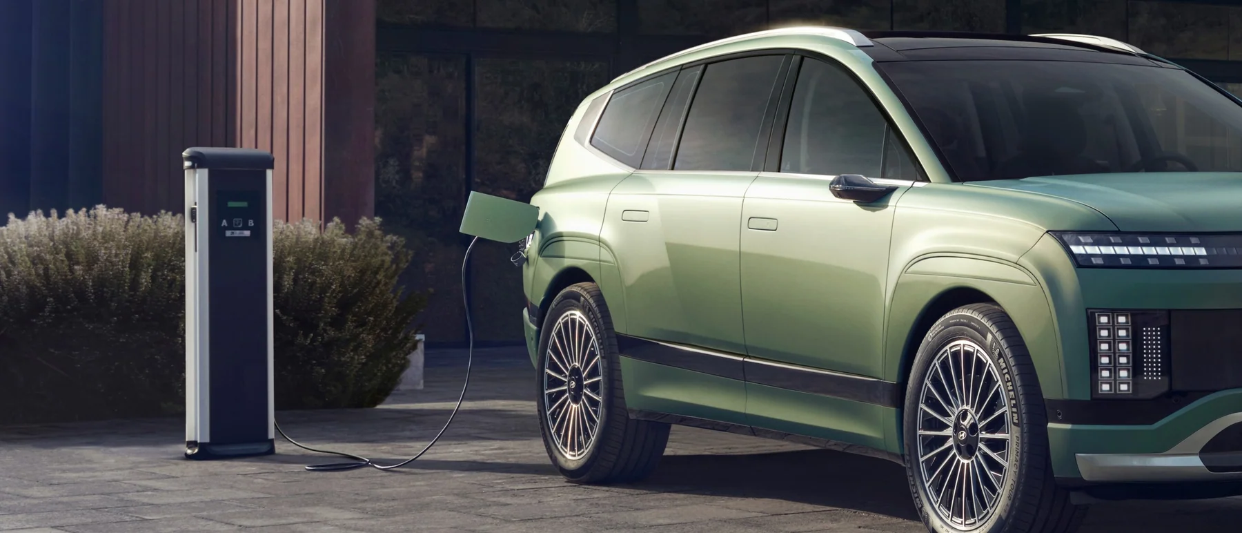 Hyundai IONIQ 9 ansluten till en laddstolpe med kabeln i laddluckan