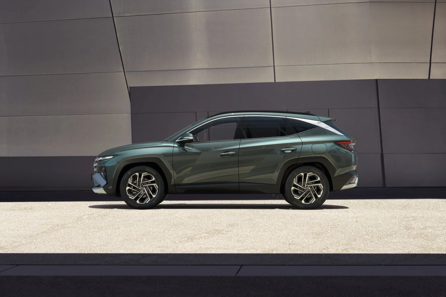 Hyundai TUCSON Plug-in Hybrid i profil framför en byggnad